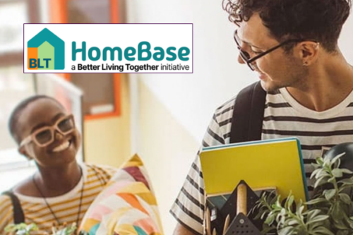 A person with short, dark hair, wearing glasses and carrying items for a home is looking over his shoulder at a smiling person wearing glasses while both climb stairs.